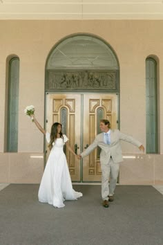 a bride and groom are holding hands in front of the doors