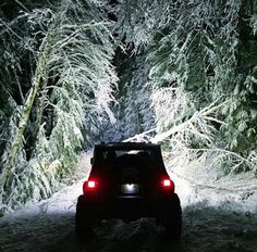 a jeep driving through the snow at night