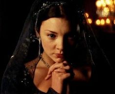a woman wearing a veil and holding her hands to her chest