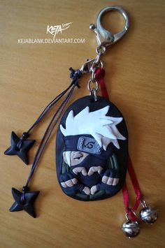 a keychain with an image of naruto and two bells hanging from it