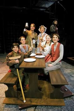 a group of people sitting around a wooden table