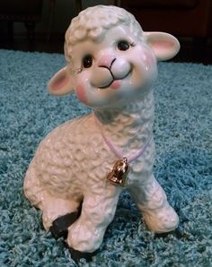 a ceramic sheep figurine sitting on top of a blue carpet