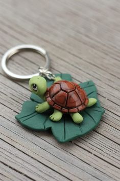 a keychain with a turtle on it sitting on top of a wooden table