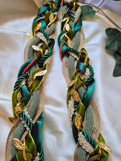 a green and gold bracelet laying on top of a bed