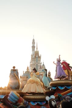 there is a float that has princesses on it in front of a castle with other floats