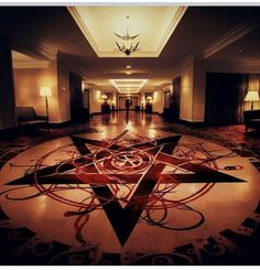 a large star is in the middle of a hallway with chandeliers on either side