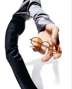 a person holding onto some glasses with one hand and the other pointing at them in different directions