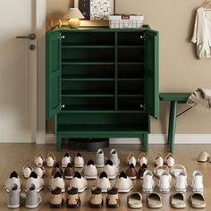 there are many pairs of shoes on the floor in front of a cabinet and table