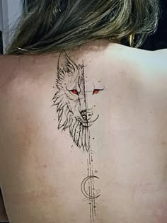 the back of a woman's neck with a wolf and compass tattoo on it