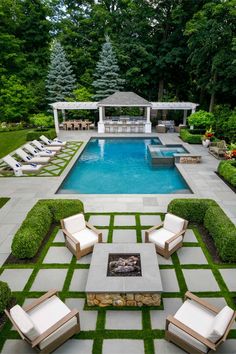 an outdoor patio with chairs and a fire pit in the center, surrounded by grass