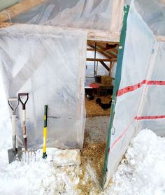 the inside of a building with snow on the ground and shovels in front of it