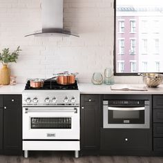 a white stove top oven sitting inside of a kitchen next to a counter with pots and pans on it