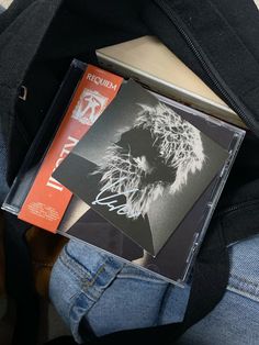a cd case sitting on top of someone's jeans