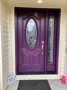 a purple front door with a sign on the side