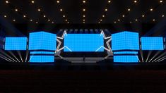 an empty stage with blue lights and chairs