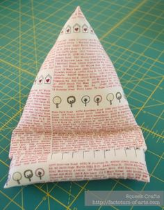 a piece of fabric is folded up on a cutting board with a ruler in front of it