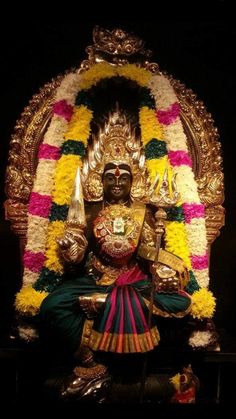 the statue is decorated with flowers and gold