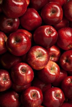 a pile of red apples sitting next to each other