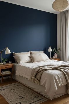 a bedroom with blue walls and white linens on the bed, along with two lamps
