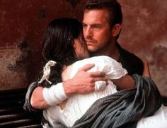 a man holding a woman on top of a wooden bench