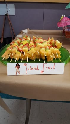 there is a plate full of fruit on the table with sticks sticking out of it