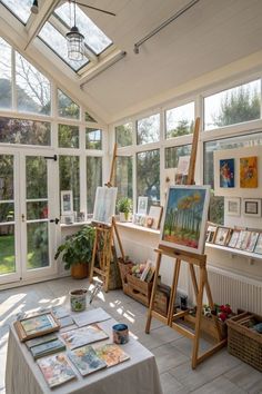 an artist's studio with large windows and paintings on easels in the foreground