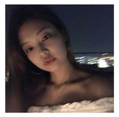 a woman with no shirt on posing in front of a cityscape at night