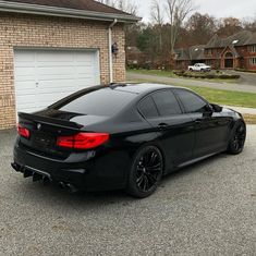 a black car parked in front of a house