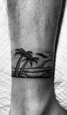 a man's foot with a palm tree tattoo on the side of his leg
