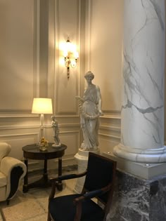 a chair and table in a room with marble columns