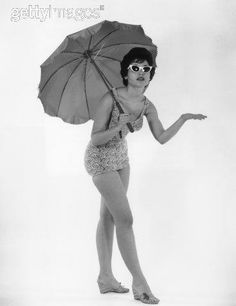 a woman in a bathing suit holding an umbrella