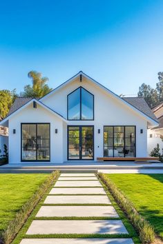 a white house with large windows and grass