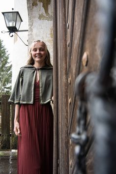 a woman standing in front of a wooden door