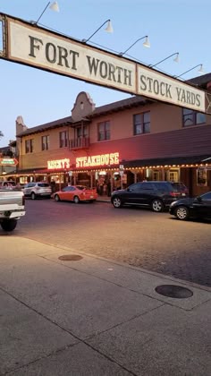 cars are parked on the street in front of stores
