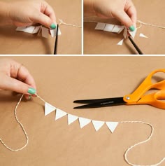 a person cutting paper with scissors on top of a piece of cardboard and twine