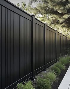 a black fence is next to some plants