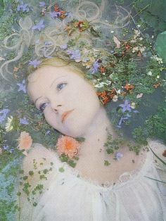 a woman with flowers in her hair is surrounded by greenery and bluebells