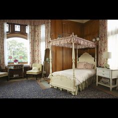 a four poster bed sitting in a bedroom next to a window