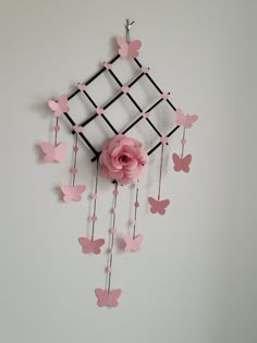 a pink flower and some butterflies on a white wall