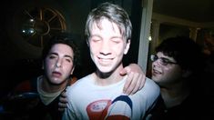 two men standing next to each other in front of a camera