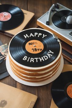 a record cake with the words happy birthday written on it and vinyl records around it