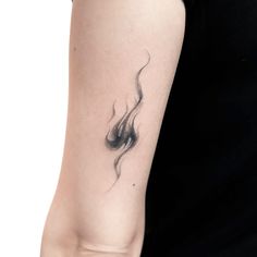 a woman's arm with a black and white fire tattoo on her left arm
