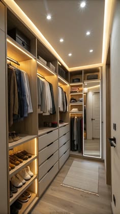 a walk in closet with lots of clothes and shoes on the shelves next to it