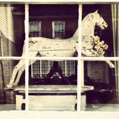 a horse statue sitting on top of a window sill