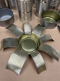 several tin cans are stacked on top of each other in the shape of a flower