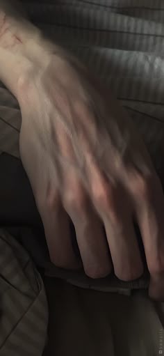 a person's hand resting on top of a pillow with their arm wrapped around them