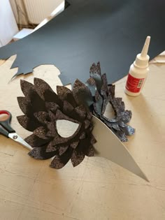 a pair of scissors sitting on top of a table next to a paper sunflower