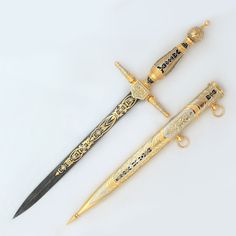 three different types of knifes with gold and black designs on the handles, one has a key chain attached to it