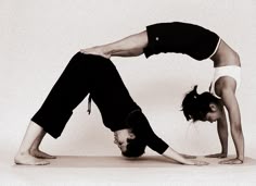 two women doing yoga poses on the floor