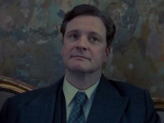 a man in a suit and tie sitting down